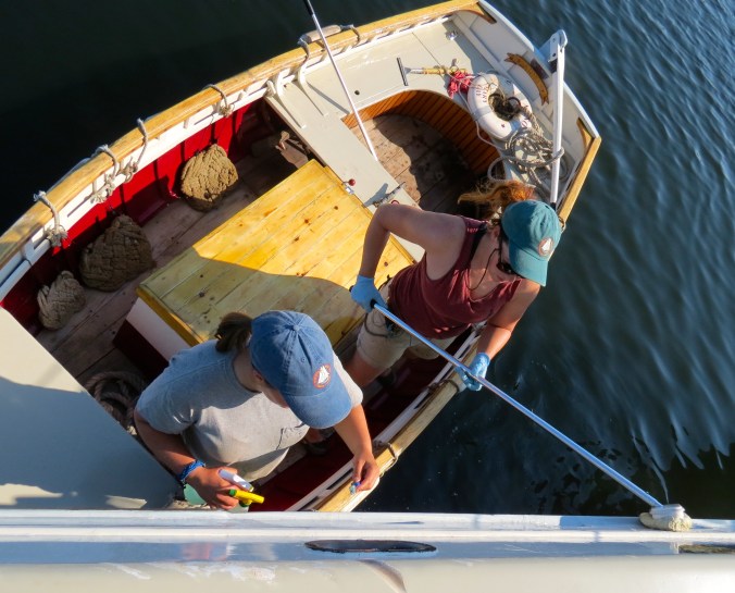 Rebecca and Hali cleaning with toothbrush and mop.